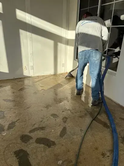 Extraction hoses and drying equipment set up on a wet floor during a Wilmington water damage job