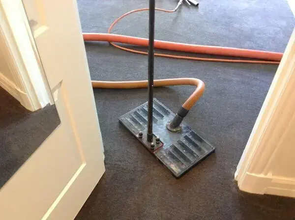 Extraction tool pulling water out of wet carpet in a Wilmington doorway