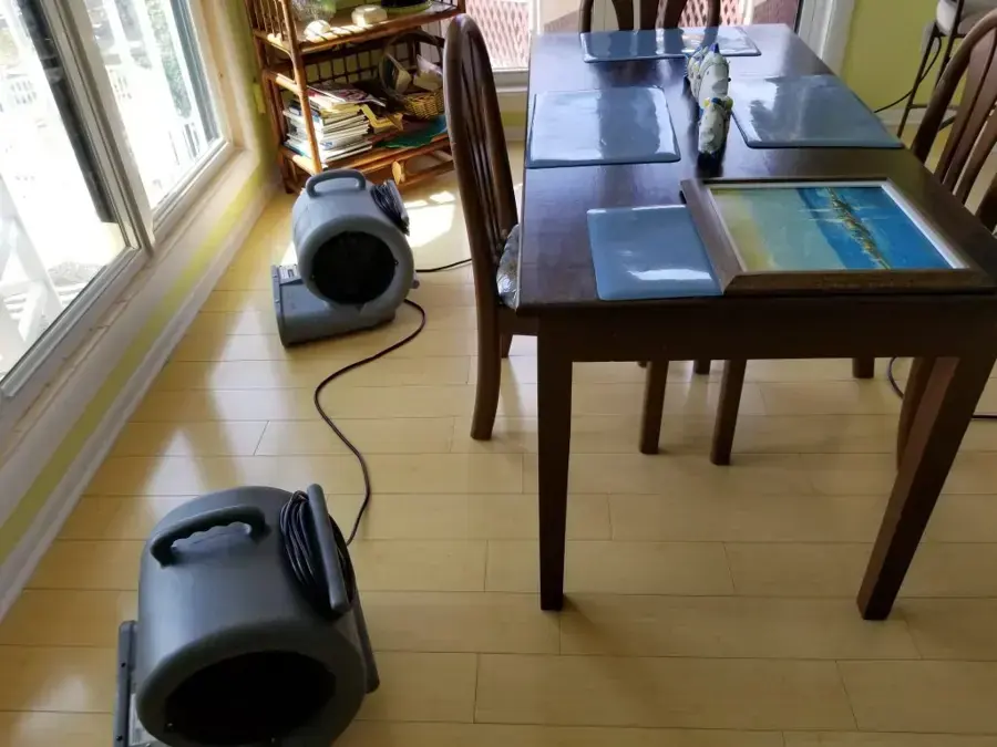Two air movers drying a dining room floor in a Wilmington home