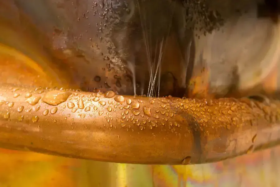 Water spraying from a leaking copper supply pipe, the start of burst pipe damage in Wilmington