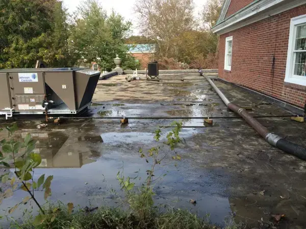Rainwater ponding around a rooftop HVAC unit on a flat roof, a common roof leak source in Wilmington