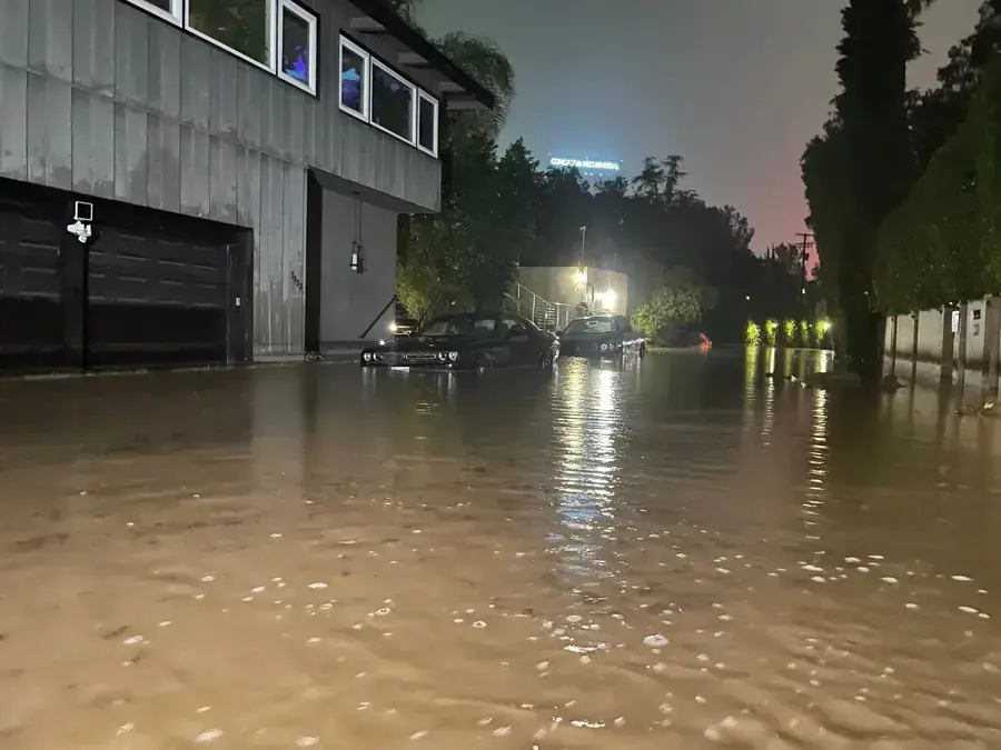 Floodwater covering a street outside garage doors at night during a winter storm near Wilmington