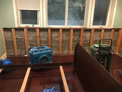 Air movers drying exposed wall studs after flood cuts during structural drying in Wilmington